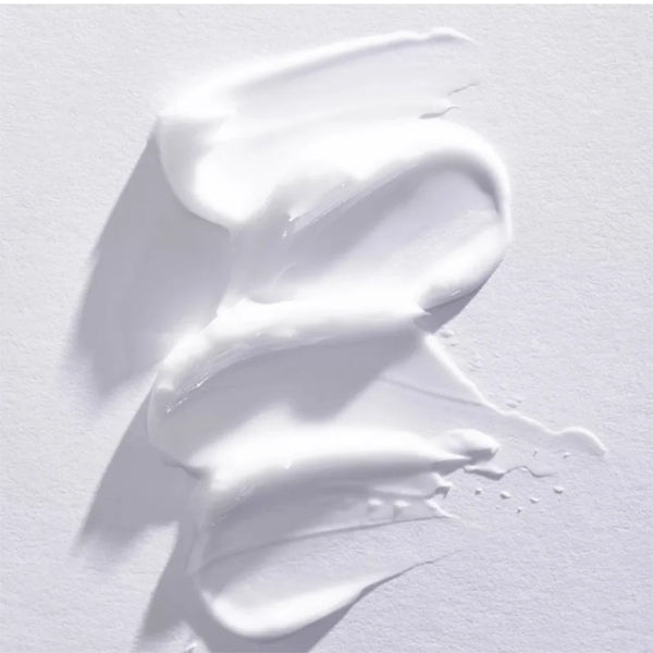 Raw Sugar Moisture Loving Lotion Shea + Rice Flower is swirled on a light surface, its white cream enriched with shea butter creating a textured pattern. Shown: 4 Pack - 16oz bottles by Raw Sugar.