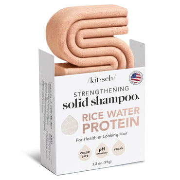A solid, light pink Kitsch All Natural Rice Water Strengthening Shampoo Bar (3.2 oz) sits partially out of a white box labeled “2 Pack - Kitsch,” highlighting its vegan, color-safe, and pH-balanced formula.