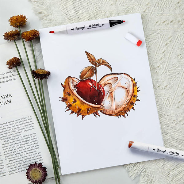 A realistic drawing of a split chestnut fruit on Bianyo Bleedproof Marker Paper Pad A4, surrounded by alcohol markers, dried flowers, and a partially seen open book. Product: 2 Pack - 50 Sheets, 18 LB/70 GSM.