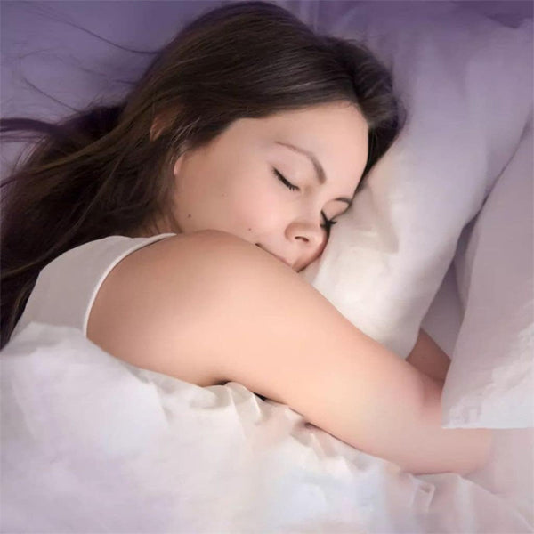A woman with long brown hair sleeps peacefully on a white pillow, possibly supported by Vicks ZzzQuil Pure Zzzs Triple Action Gummy Melatonin Sleep Supplement (2 Pack, 42ct).
