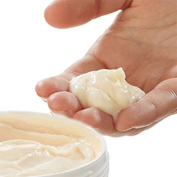 A hand scooping Garnier Whole Blends Repairing Honey Extracts Mask from an open 10.1oz container, part of the 2 Pack set.