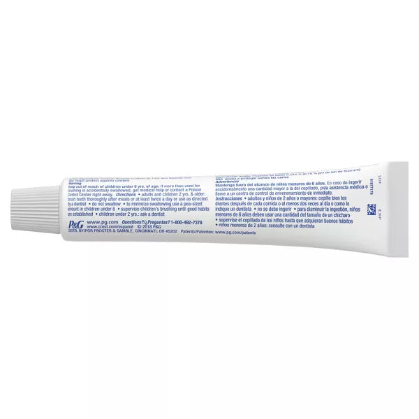A white tube with a ribbed cap lies on its side, displaying blue text with product info and instructions for Crest 2 Pack + Scope Complete Whitening Toothpaste Minty Fresh 5.4oz (3 count each).