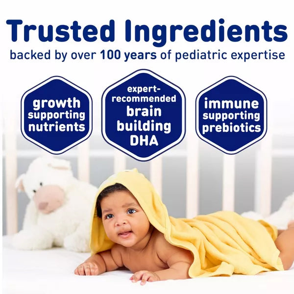A baby lies on a bed with a yellow towel, as text highlights Enfamil 2 Pack Milk-Based Powder Infant Formula’s brain-building DHA and immune support, trusted by parents for over 100 years.