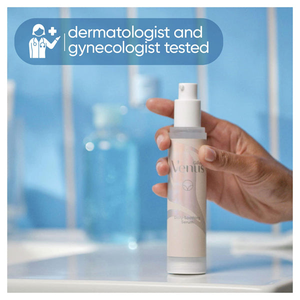 A hand holds a bottle of Gillette Venus Intimate Grooming Daily Soothing Serum 1.7oz in a bathroom, with a label at the top left stating dermatologist and gynecologist tested.