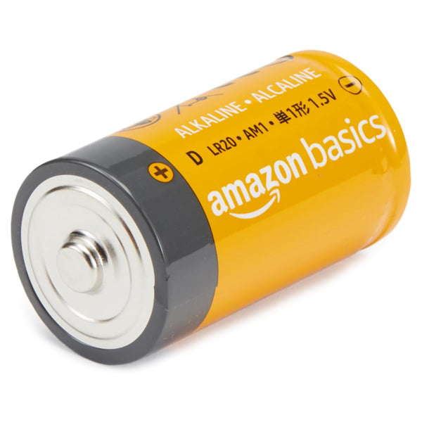 An Amazon Basics 1.5V D Cell Alkaline Battery from a 12-pack, with a yellow label and visible product info, rests on its side showing the positive terminal—ideal for emergency devices and offering dependable 5-year shelf life.