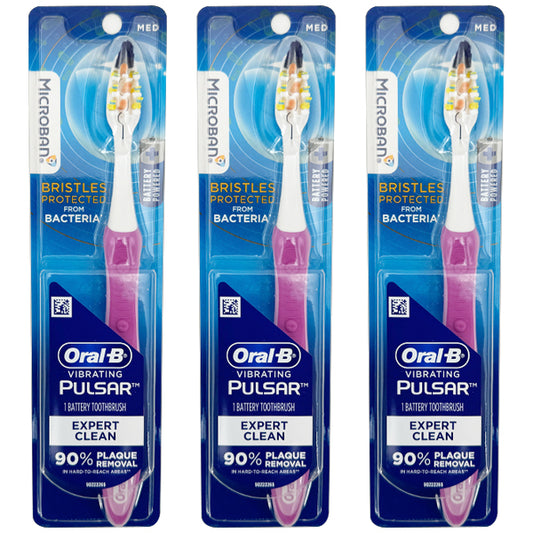 Three Oral-B Vibrating Pulsar Battery Toothbrushes, Expert Clean Medium Bristles in pink, are shown standing vertically side by side. Sold as a 3 Pack, they help remove up to 90% of plaque with powerful vibrating bristles.