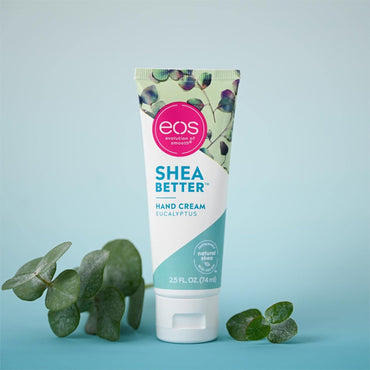 A 2 Pack of EOS Eucalyptus Natural Shea Butter Hand Lotion (2.5oz) stands upright on a light blue surface, providing lasting hydration, with eucalyptus leaves arranged nearby.