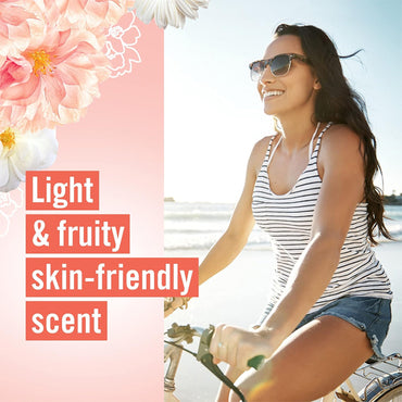 A woman in sunglasses and a striped tank top rides a bicycle on the beach; text reads Light & fruity Vagisil Scentsitive Scents Feminine Dry Wash Deodorant Spray for intimate skin, 3 Pack, on a pink floral background.