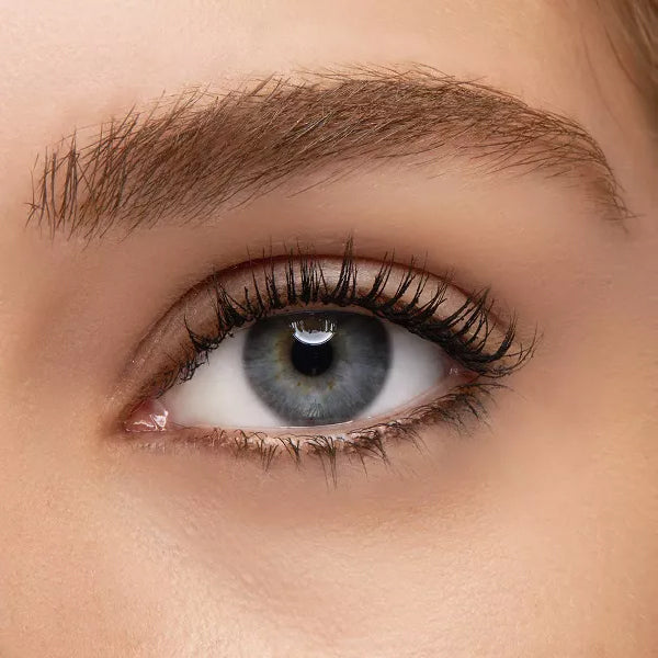 Close-up of a persons blue eye with fanned-out, long lashes and a well-groomed eyebrow, achieved using Revlon Volumazing Mascara 901 Blackest Black (3 Pack) by Revlon.