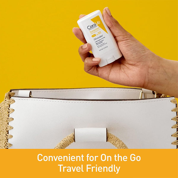 A hand holds a CeraVe Mineral Sunscreen Stick SPF 50 (3 Pack, 0.47oz) above a white handbag, showcasing its travel-friendly design and convenient broad spectrum UV protection for on-the-go use.