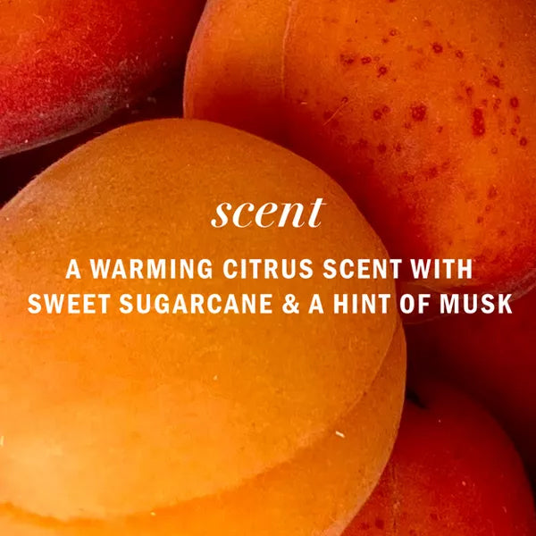 Close-up of ripe peaches with overlaid clear white text: Herbal Essences 3 Pack Apricot Oil Curl Defining Shampoo, 13.5oz, features a warming citrus scent with sweet sugarcane, apricot oil, and a hint of musk.