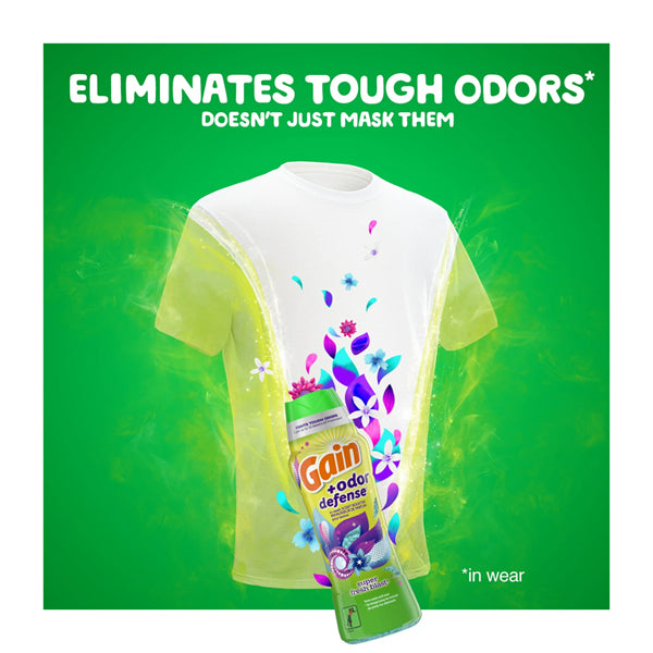 A white t-shirt with floral graphics is surrounded by green mist. In front, a 5 Pack of Gain + Odor Defense In-Wash Scent Booster Super Fresh Blast Scent is shown. Text above reads: Eliminates tough odors for lasting freshness.