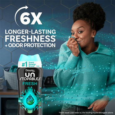 A woman smiles and lifts her sweater, enjoying the Fresh Scent of Downy Unstopables Laundry Scent Booster Beads (5 Pack, 5.7 oz), highlighting 6x longer-lasting freshness and odor protection from Downy.