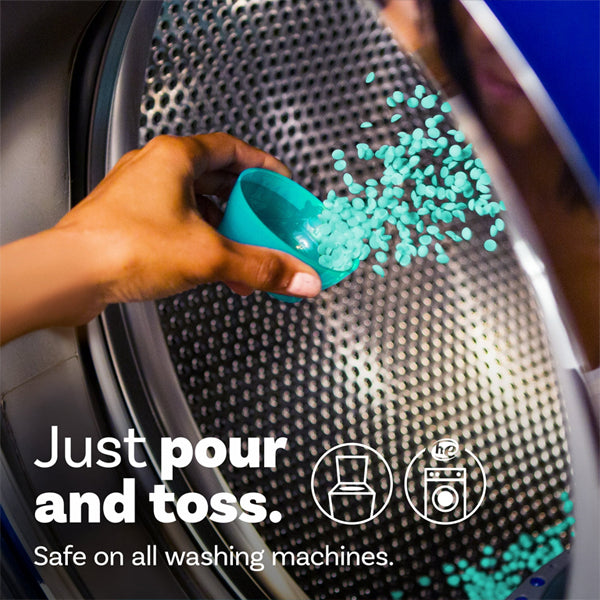 A hand pours Downy Unstopables Laundry Scent Booster Beads Fresh Scent 5.7 oz into a washer. Text: Just pour and toss. Enjoy a fresh scent—safe for all machines. Available in 5 pack from Downy.
