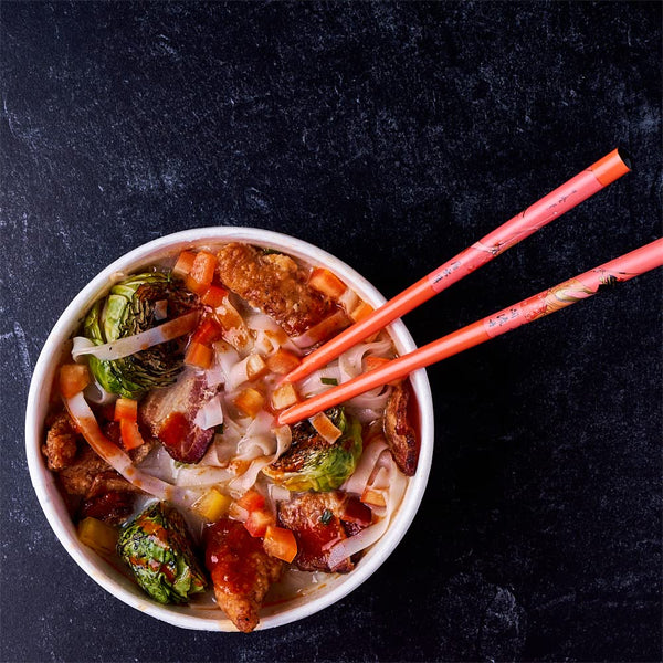 Enjoy a bowl from the Snapdragon 6 Pack Laksa Curry Instant Noodle Bowls, featuring coconut curry flavor noodles with vegetables and spices, inspired by Southeast Asian cuisine.
