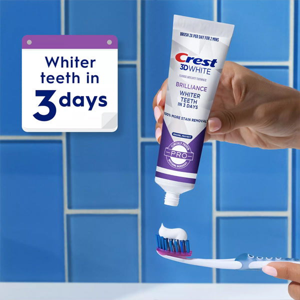 A hand squeezes Crest 3D White Brilliance Pro Enamel Protect Toothpaste (3oz, 6 Pack) onto a toothbrush against a blue tiled background, with a sign reading Whiter teeth in 3 days and highlighting enamel-safe whitening.