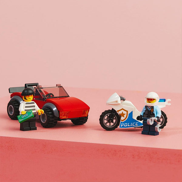 LEGO City Police Bike Car Chase 60392 by LEGO includes a thief with cash and a police officer with handcuffs, plus a red car and white police motorbike—perfect for action-packed chases against a bright pink backdrop.