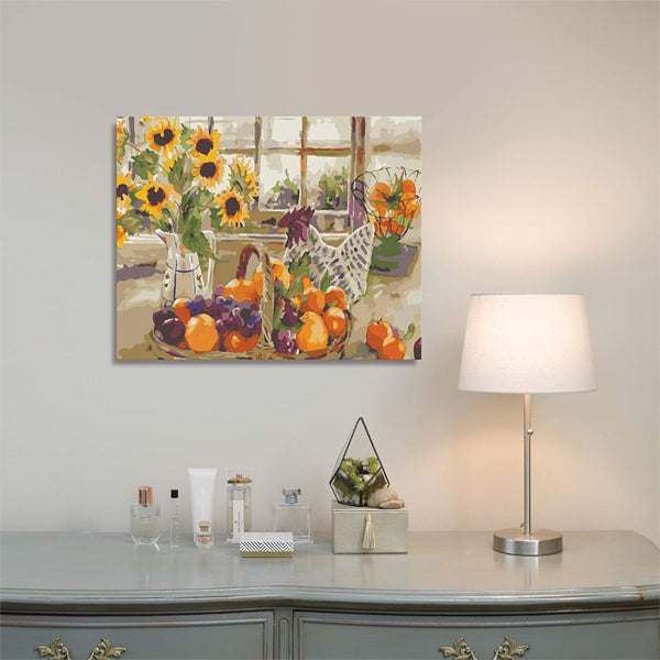 The Ledgebay Paint by Number for Adults Framed Canvas Country Sunshine 16 x 20 hangs above a dresser with toiletries, a terrarium, and a lit lamp, set against a light-colored wall.