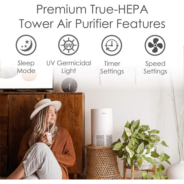 A woman relaxes in a cozy room with the Crane Air Purifier with True HEPA Filter Germicidal UV Light EE-5068, surrounded by plants and wood furniture. Features include sleep mode, UV light, timer, and adjustable speed settings.