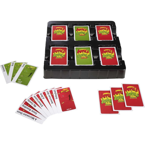 The image shows Mattel Games Apples to Apples Junior the Game of Crazy Comparisons! by Mattel, with its tray holding multiple decks and several red and green cards spread on a white surface for fun vocabulary-boosting play.