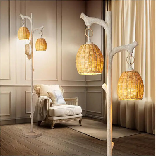 A cozy room with a cushioned armchair and the Scenekoy 68 High Farmhouse Rustic Country Cottage Floor Lamp, a tree trunk faux wood design with three wicker drum shades, stands out against paneled walls and wooden flooring.