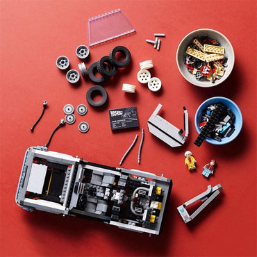 LEGO car parts, wheels, and two minifigures are displayed with sorted pieces and a partially built LEGO Back to the Future DeLorean DMC-12 10300—an ideal building kit for adult fans of Back to the Future from LEGO.