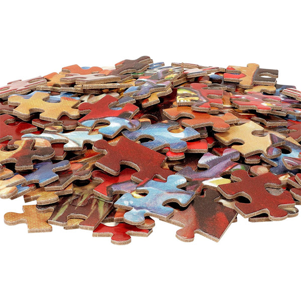 A pile of colorful pieces from the Mattel Games Masters of The Universe 500 Piece Jigsaw Puzzle is scattered on a white surface.