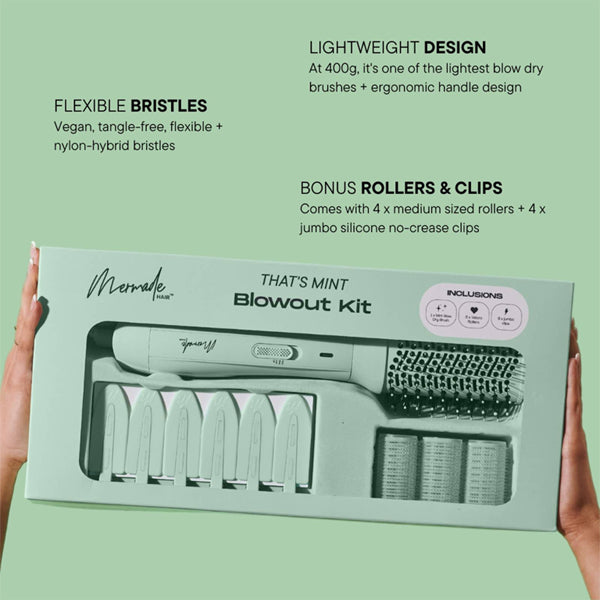 A person holds a packaged Mermade Hair Thats Mint Three Piece Blowout Kit, which includes an Ionic Blow-Dry Brush, four medium rollers, four jumbo rollers, and four clips. Key features are displayed on the box.