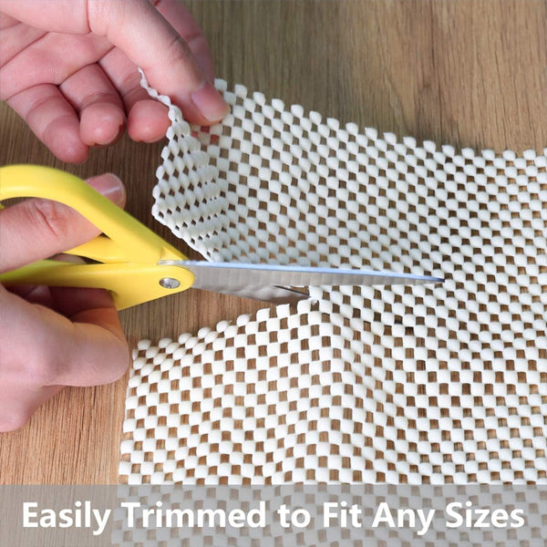 Hands using yellow scissors cut a 3x5 Unbranded Non Slip Area Rug Pad Gripper on wood. Text: Easily Trimmed to Fit Any Size. 2 Pack for Area Rugs and Hardwood Floors.