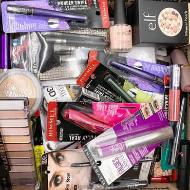 A lot of 50 unopened Wholesale Mixed Makeup & Beauty Tools by Deal Society, including eyeliners, mascaras, lipsticks, nail polishes, and eyeshadow palettes.
