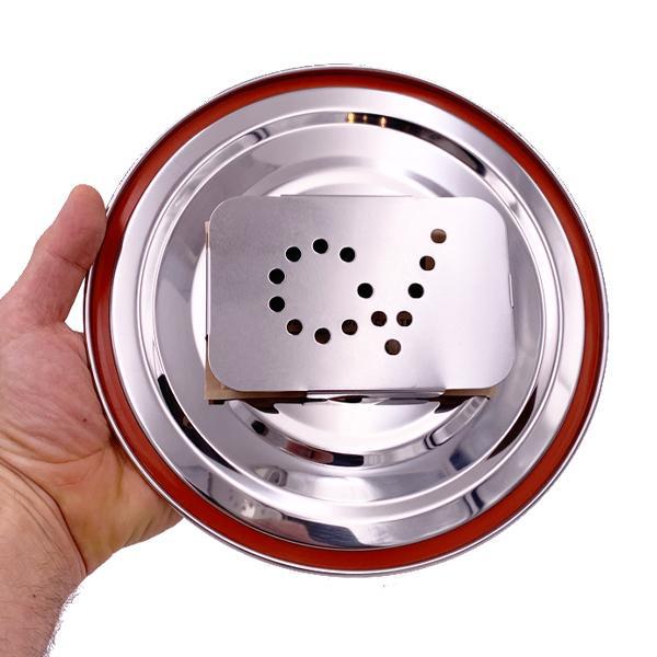 A hand holds a round stainless steel plate with a red rim, featuring the CVault 4 Liter Humidity Control Airtight Metal Stash Container by CVault.