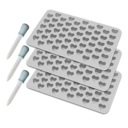 The Deal Society Silicone Gummy Heart Mold 3 Pack includes three premium trays with small heart-shaped molds and two plastic droppers with blue bulbs—perfect for versatile use in your kitchen.