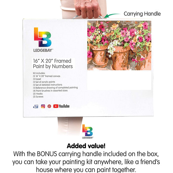 Person holding a Ledgebay Paint by Numbers Kit for Adults - Sweet Petunias 16 x 20 framed set, featuring a partially completed floral painting on premium canvas—a perfect gift for fans of Ledgebay artwork.