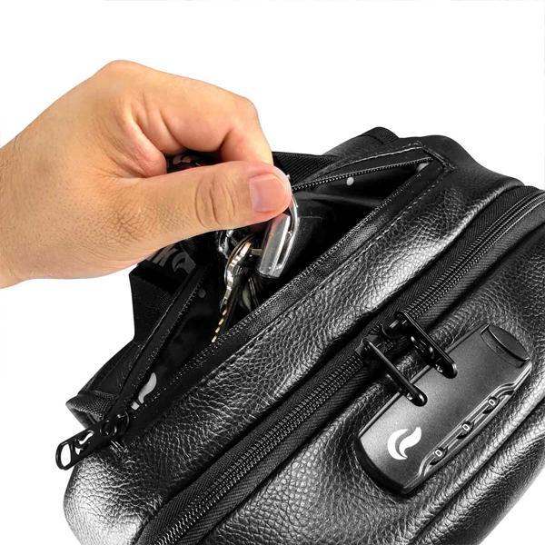 A hand is placing keys into the partially open zippered pocket of a black Skunk Elite Backpack, a smell proof, weather proof stash bag with combo lock and textured design.